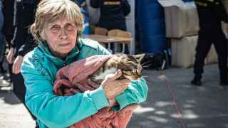Эвакуированная женщина держит на руках кота.